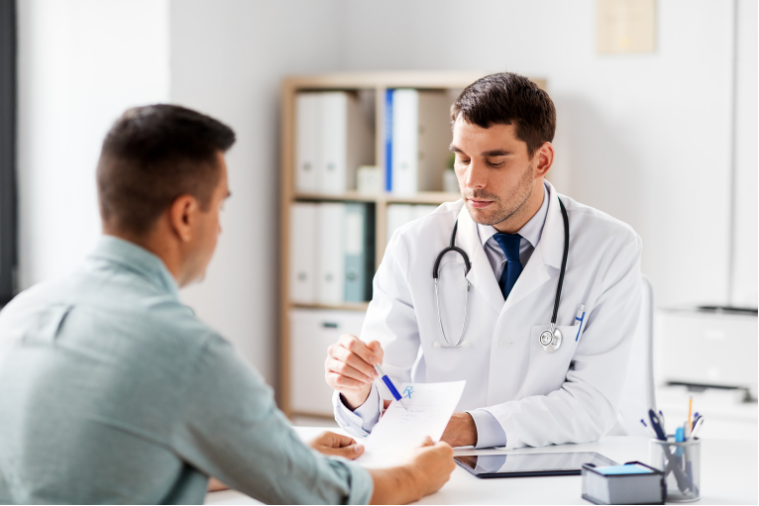A doctor discusses paperwork with a patient in a medical office.